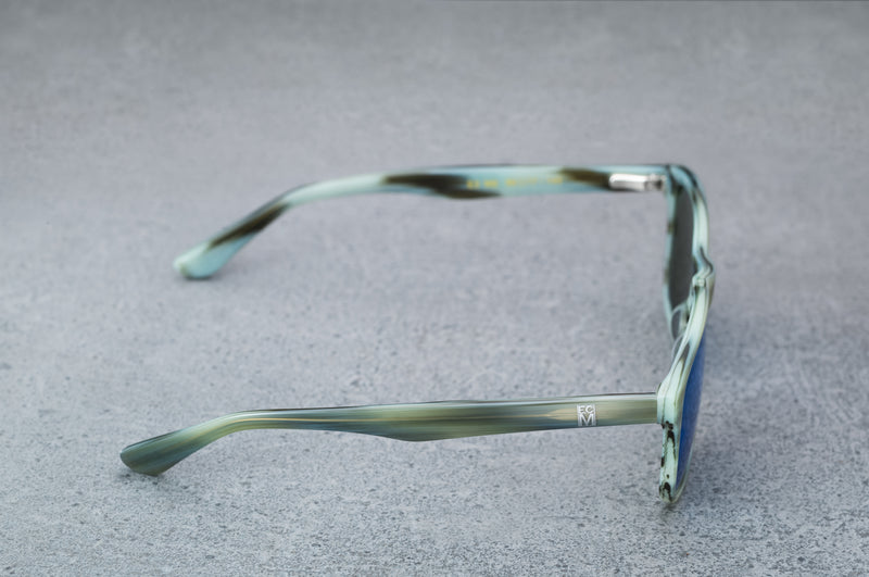 Light green sunglasses with reflective blue lenses, open, facing right showing the frames.