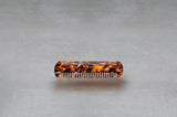 4 inch beard comb made of red, black, and amber Italian acetate.