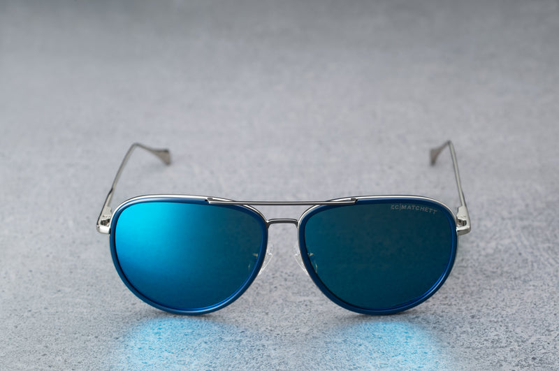 Silver aviator style sunglasses with reflective blue lenses, open, facing forward.