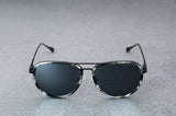 Black patterned sunglasses with reflective silver lenses , laying flat, facing forward with temples open..