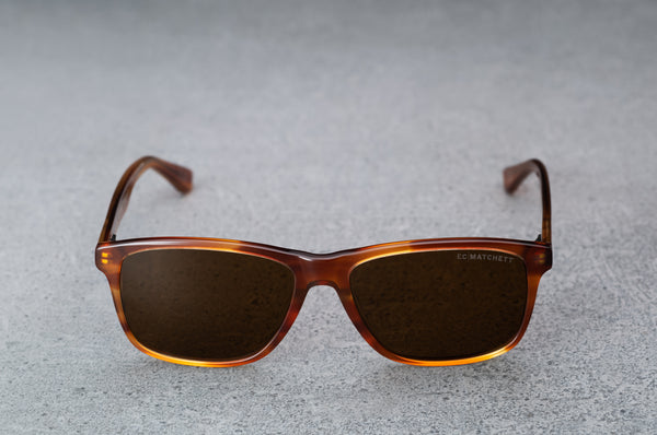 Red/brown glasses with dark brown lenses, open, facing forward.