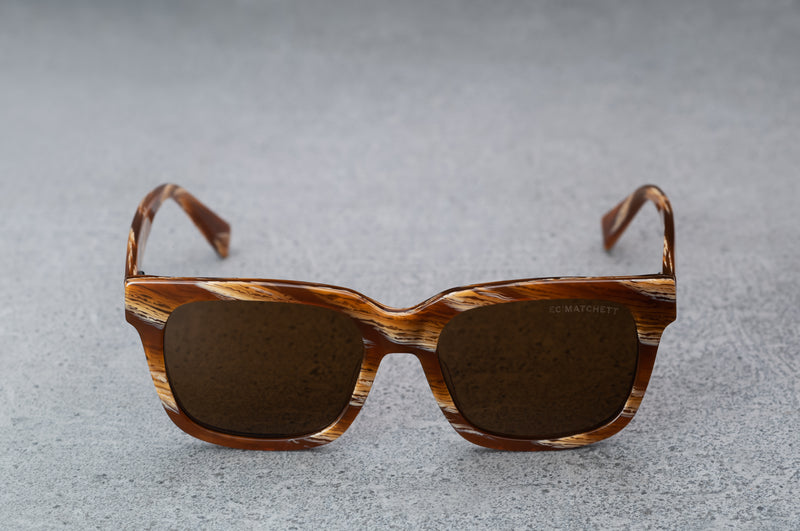 Brown and white patterned sunglasses, facing forward with temples open.