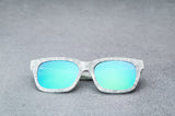 White patterned sunglasses with reflective blue lenses laying flat, facing forward.