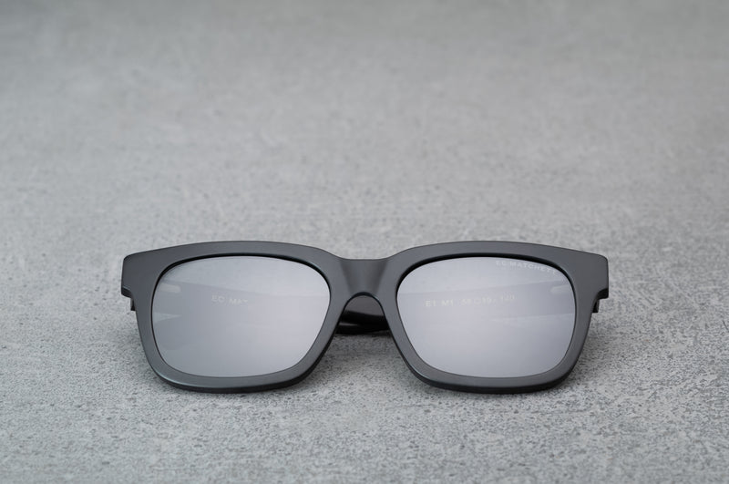 Black sunglasses with black lenses laying flat, facing forward.