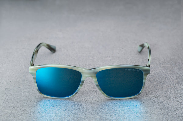 Light green sunglasses with reflective blue lenses, open, facing forward.